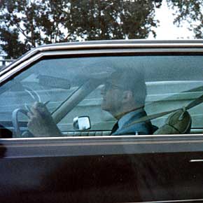 Photo: a man writes as he "drives"